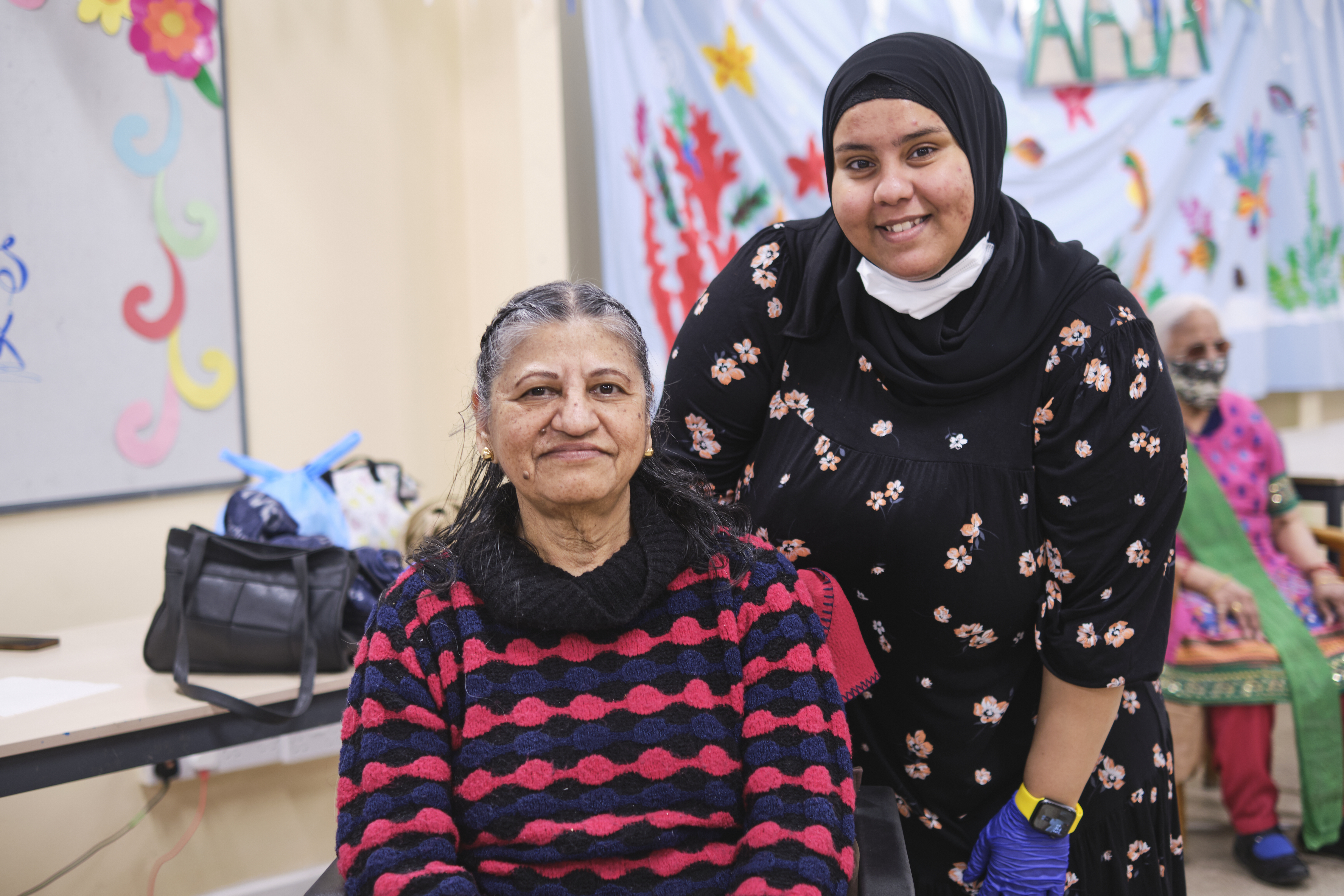 A younger woman supporting an older woman.