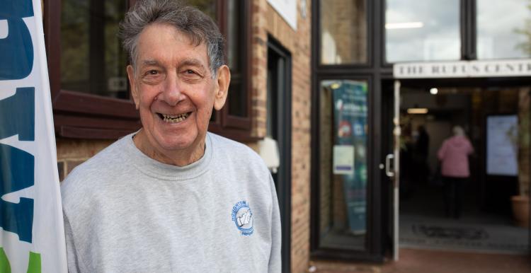 Man smiling outside building.