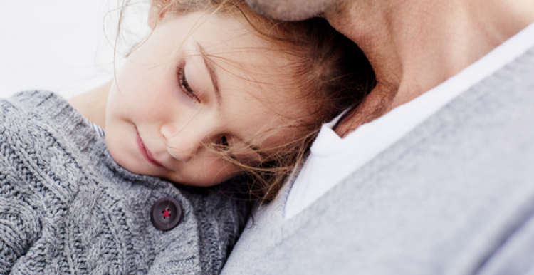 a small child in arms of father