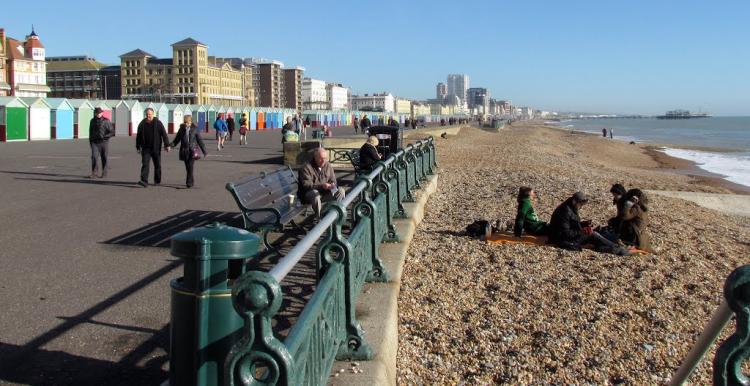 People walking along the Brighton beachfront. 