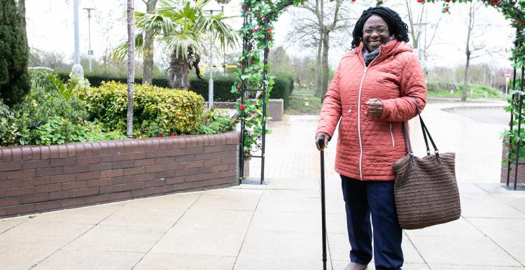 A woman walking and wearing a winter coat in the cold.