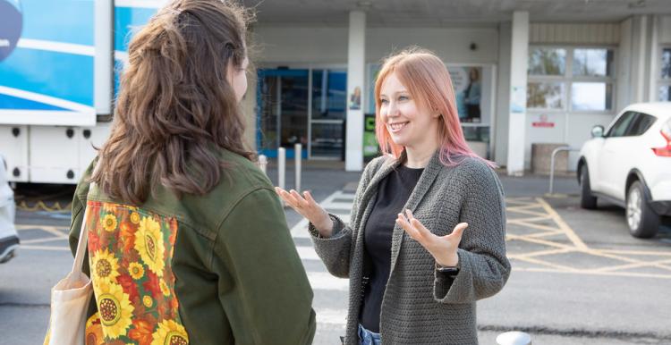 Two women talking outside of a women's services centre.