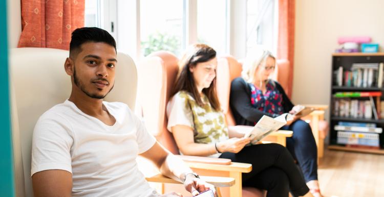 Man and women sitting in waiting roon chairs