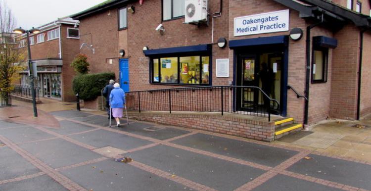 side view of GP Practice, couple walking towards entrance