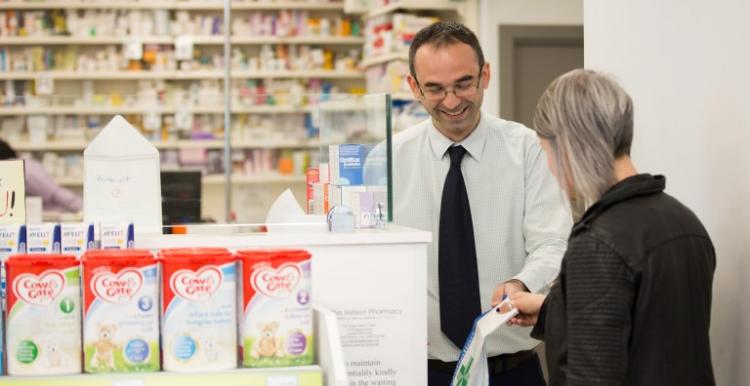 Male pharmacist serving a female customer