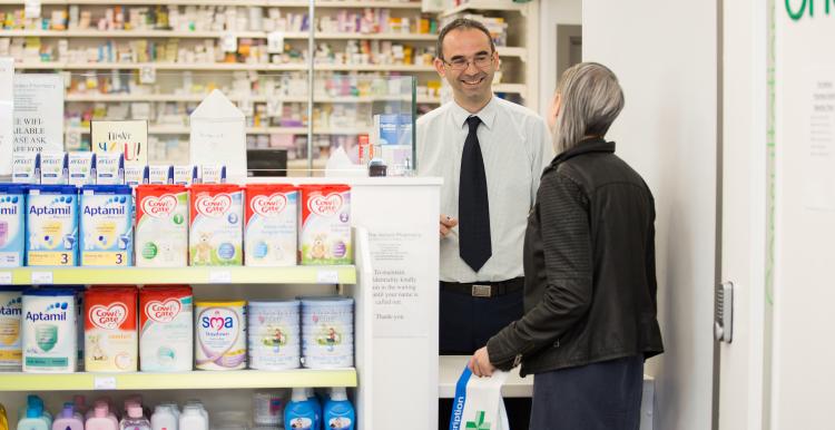 Pharmacist and customer in pharmacy.