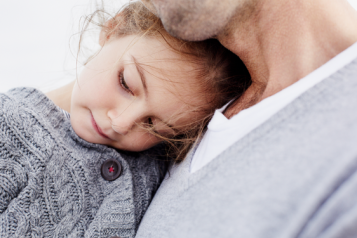 a small child in arms of father