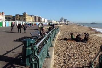 People walking along the Brighton beachfront. 