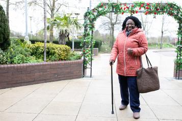 A woman walking and wearing a winter coat in the cold.