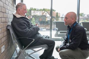 Two men talking in a reception room.