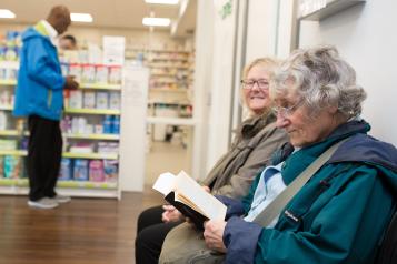 Three people waiting at a pharmacy.