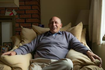 Portrait of an older man sat on the sofa.