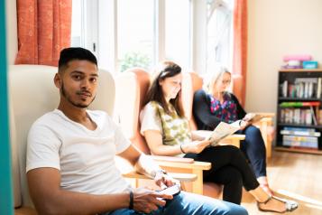 Man and women sitting in waiting roon chairs