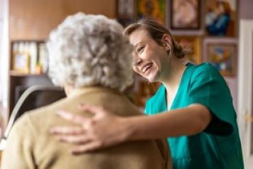 Social care worker helping woman.