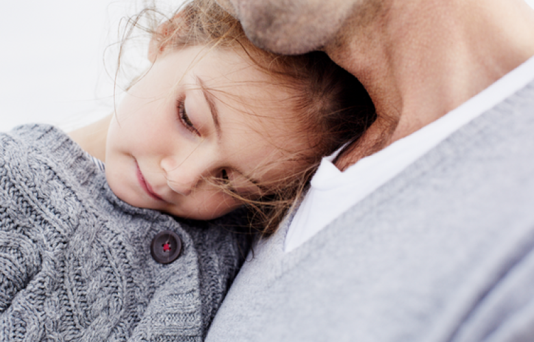 a small child in arms of father